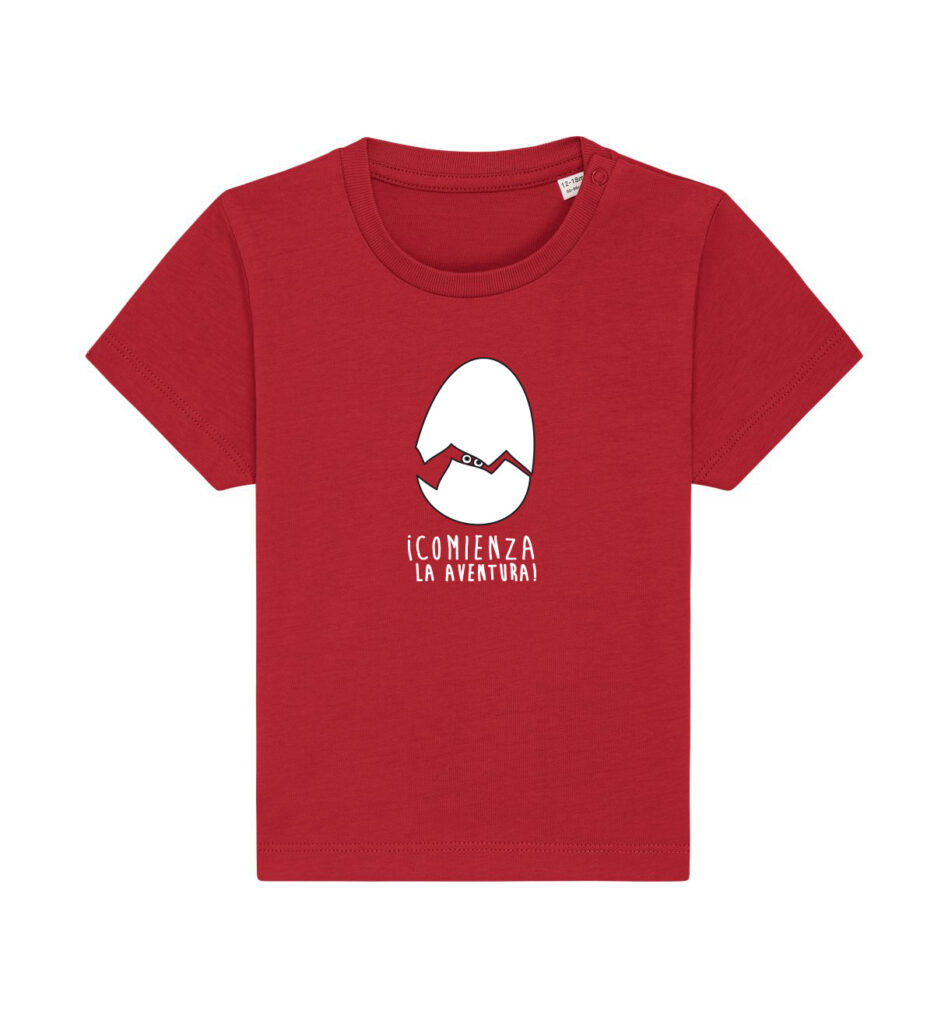 Camiseta roja para niños pequeños con una ilustración de un huevo blanco roto y el texto en español «¡Comienza la aventura!» impreso en la parte delantera.